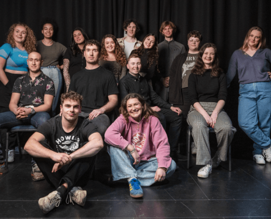 A young person working on a creative project, surrounded by art supplies and tools.